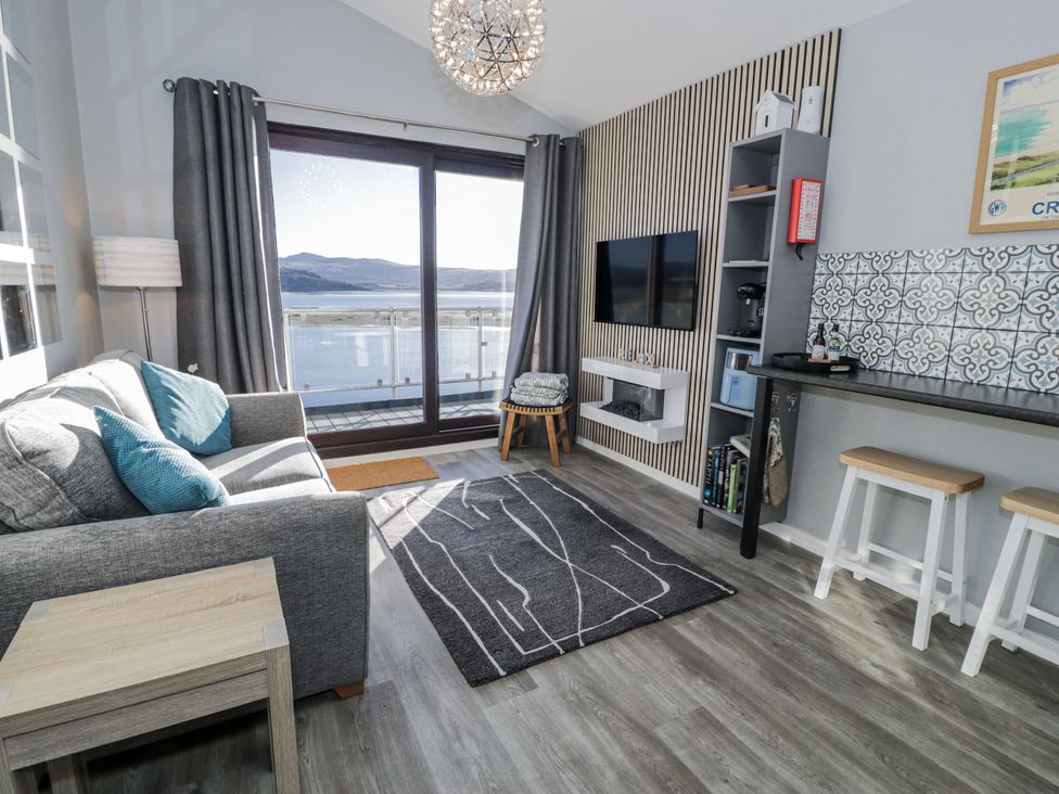A living room with a sofa and television at Estuary Escape in Porthmadog