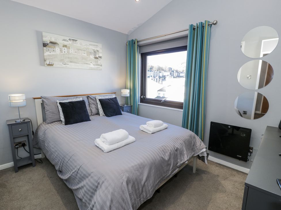 A bedroom with a bed and bedside tables at Estuary Escape in Porthmadog
