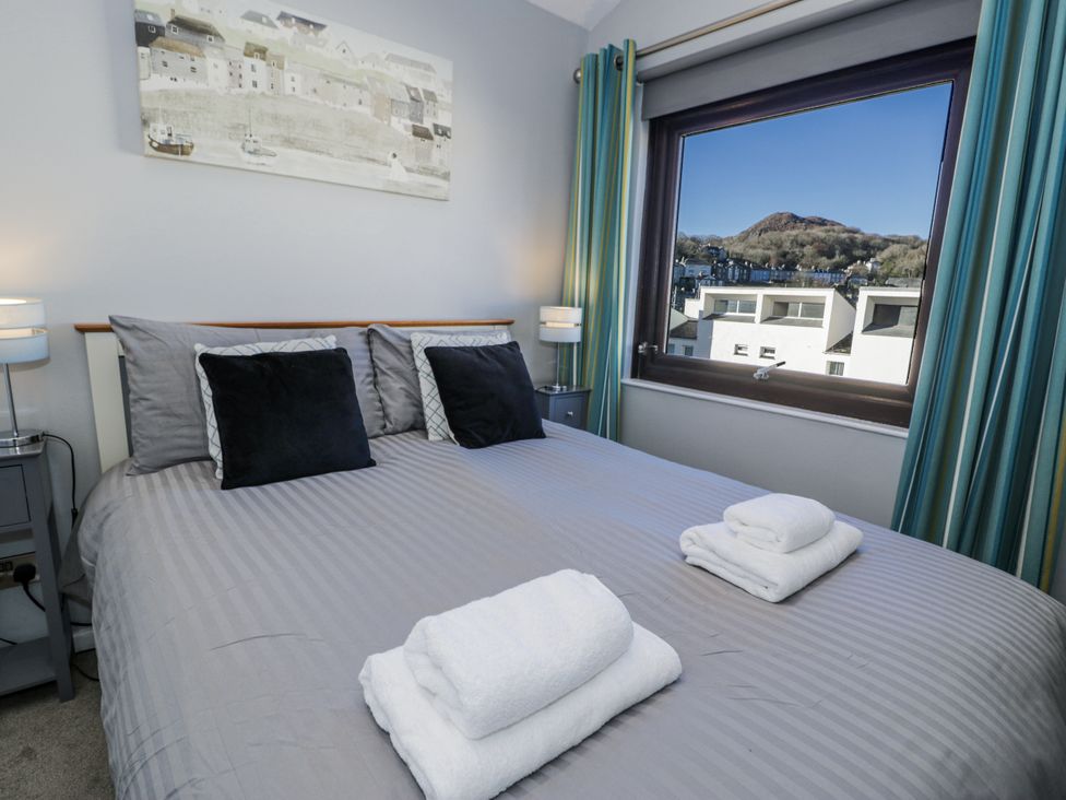 A bedroom with a bed and window view at Estuary Escape in Porthmadog