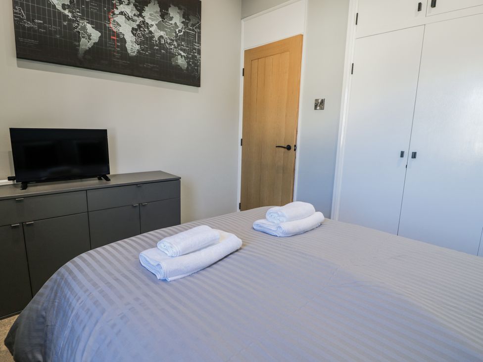 A bedroom with a bed and towels on it at Estuary Escape in Porthmadog