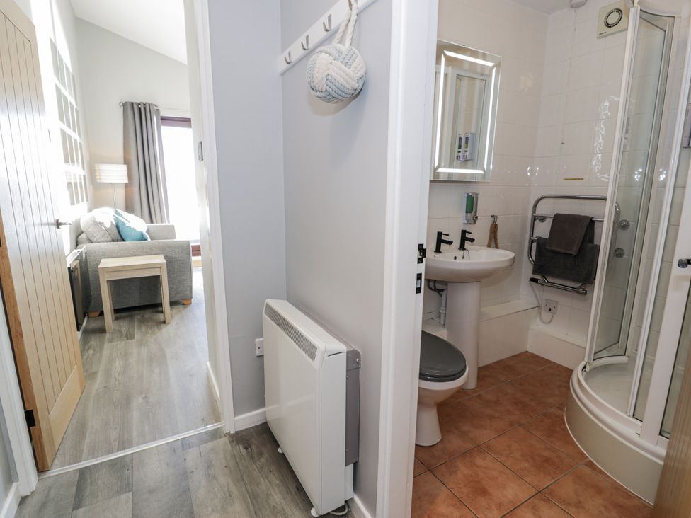 A bathroom with a wash basin and shower at Estuary Escape in Porthmadog