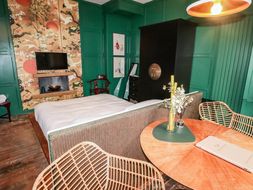 A bedroom with a bed and television at The Carriages in St Athan