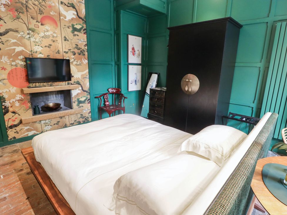 A bedroom with a bed and television at The Carriages in St Athan