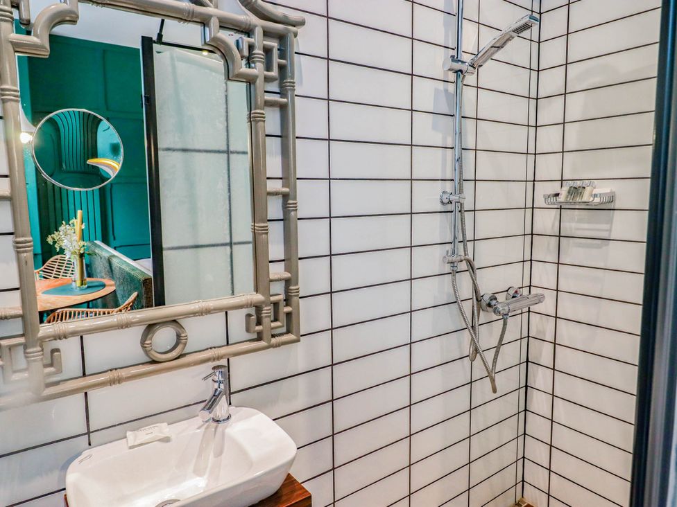 A bathroom with a shower and sink at The Carriages in St Athan