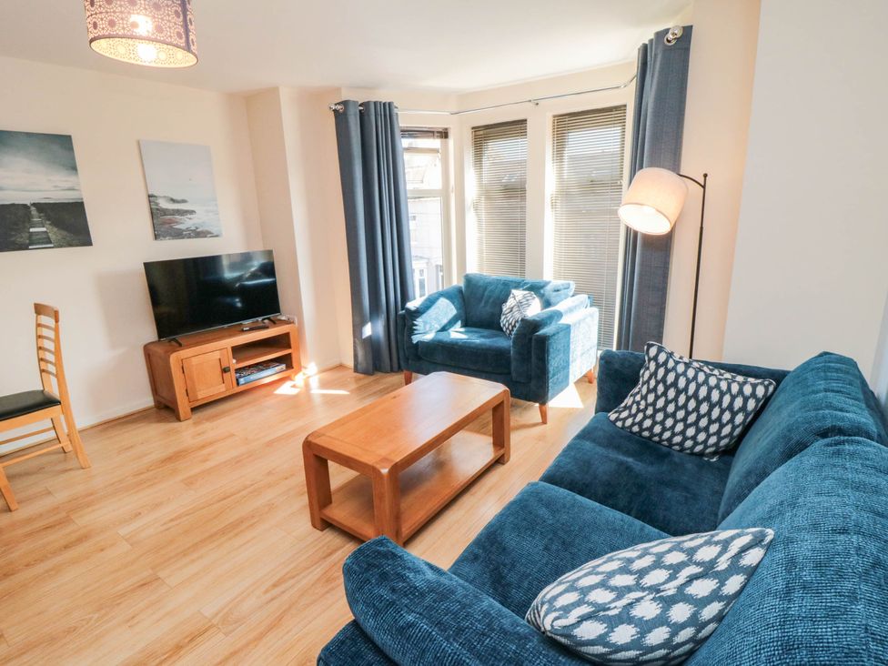 A living room with a television and sofa at Flat 17