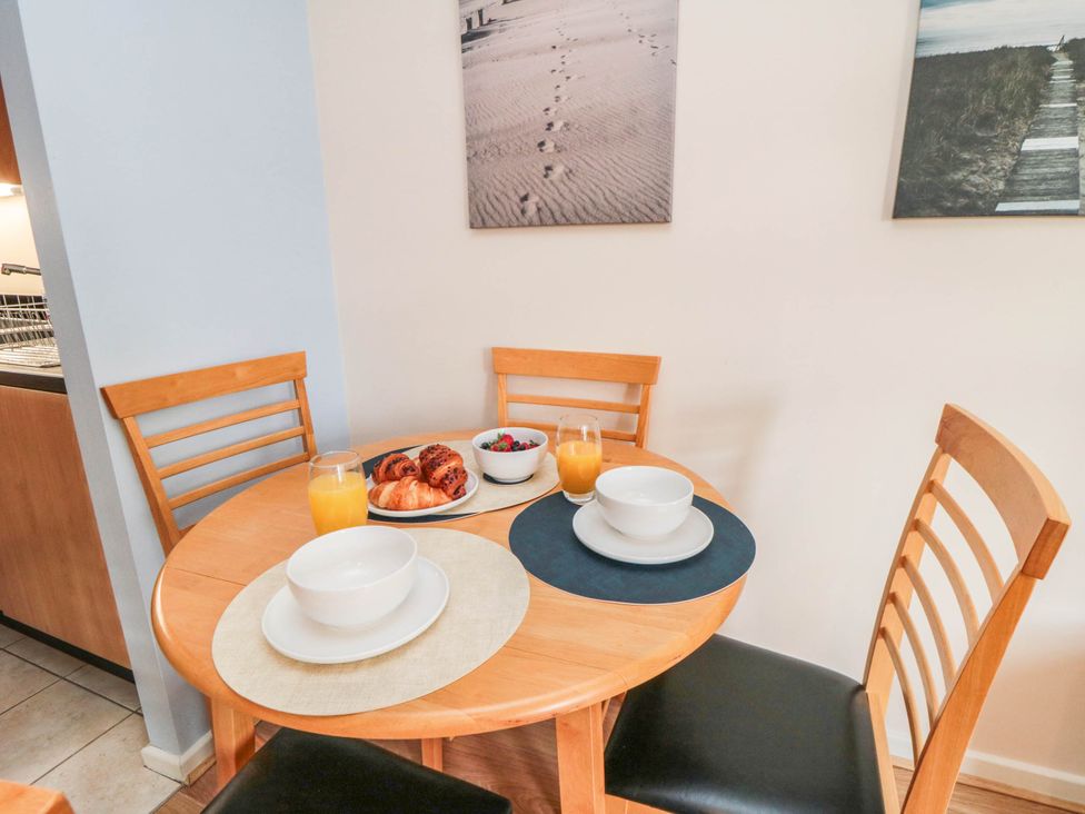 A dining room with a round table set for breakfast at Flat 17