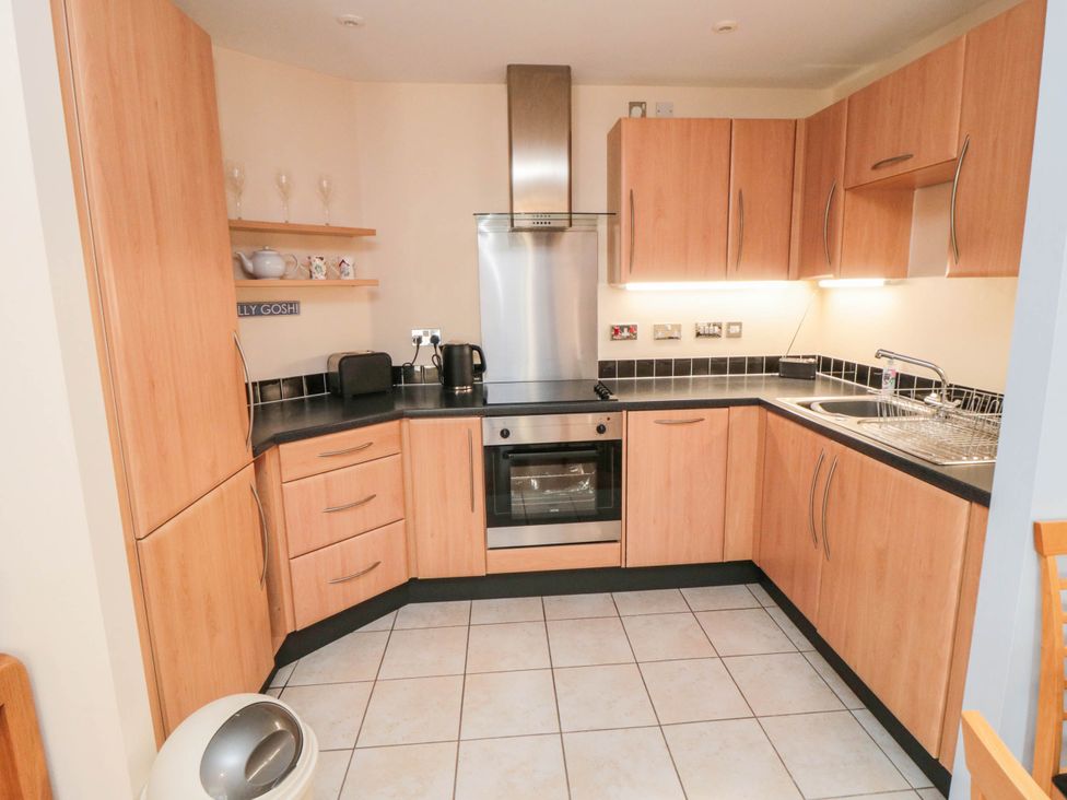 A kitchen with cabinets and appliances at Flat 17 