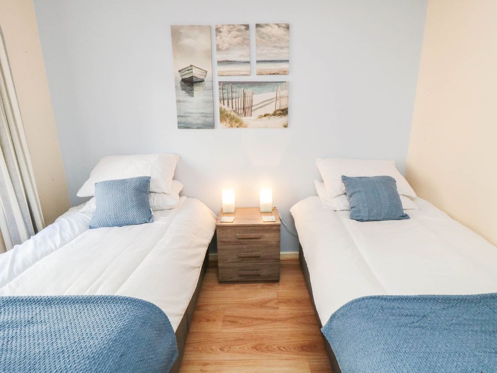 A bedroom with two beds and wall art at Flat 17