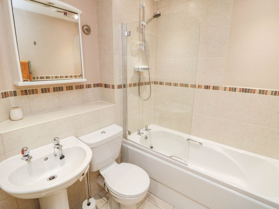 A bathroom with a bathtub, shower, sink, and toilet at Flat 17