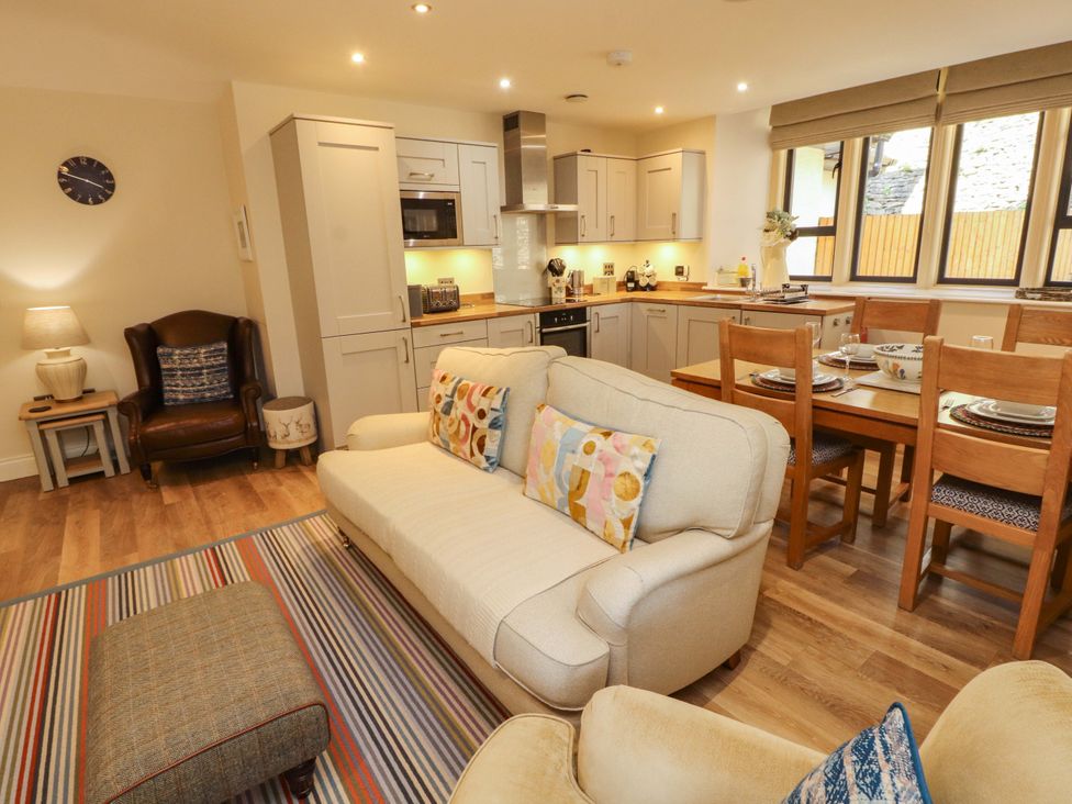 A living room with a sofa and dining table at Deer Wood At Applethwaite Hall Windermere