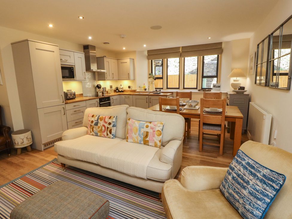 A kitchen with a sofa and dining table at Deer Wood At Applethwaite Hall in Windermere