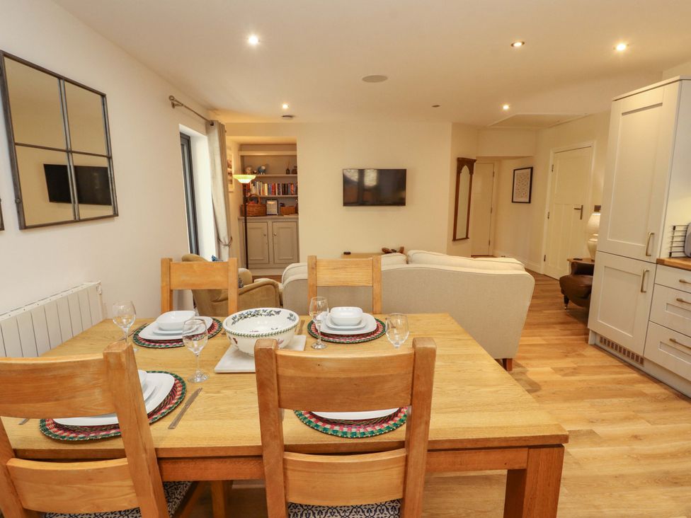 A dining room with a table and chairs at Deer Wood At Applethwaite Hall in Windermere