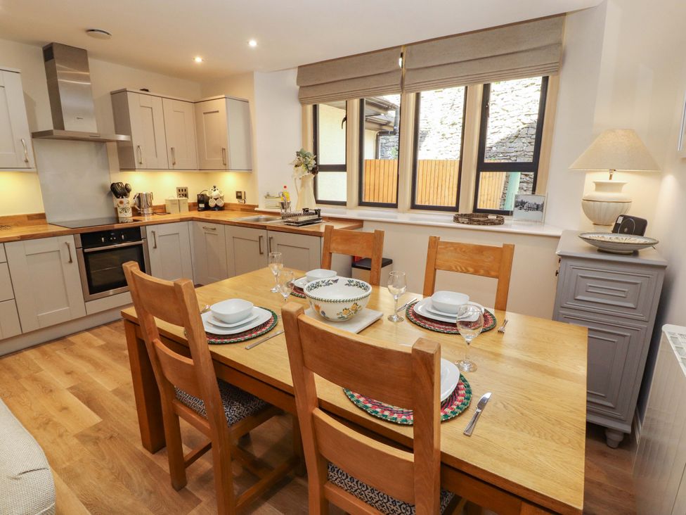 A kitchen with a dining table and chairs at Deer Wood At Applethwaite Hall in Windermere