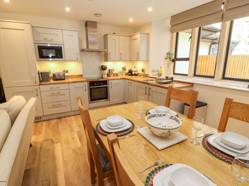 A kitchen with a dining table and chairs at Deer Wood At Applethwaite Hall in Windermere
