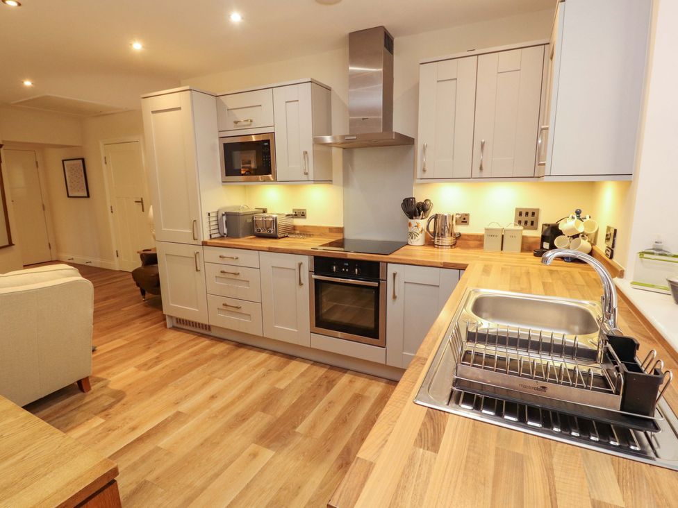 A kitchen with cabinets and appliances at Deer Wood At Applethwaite Hall in Windermere