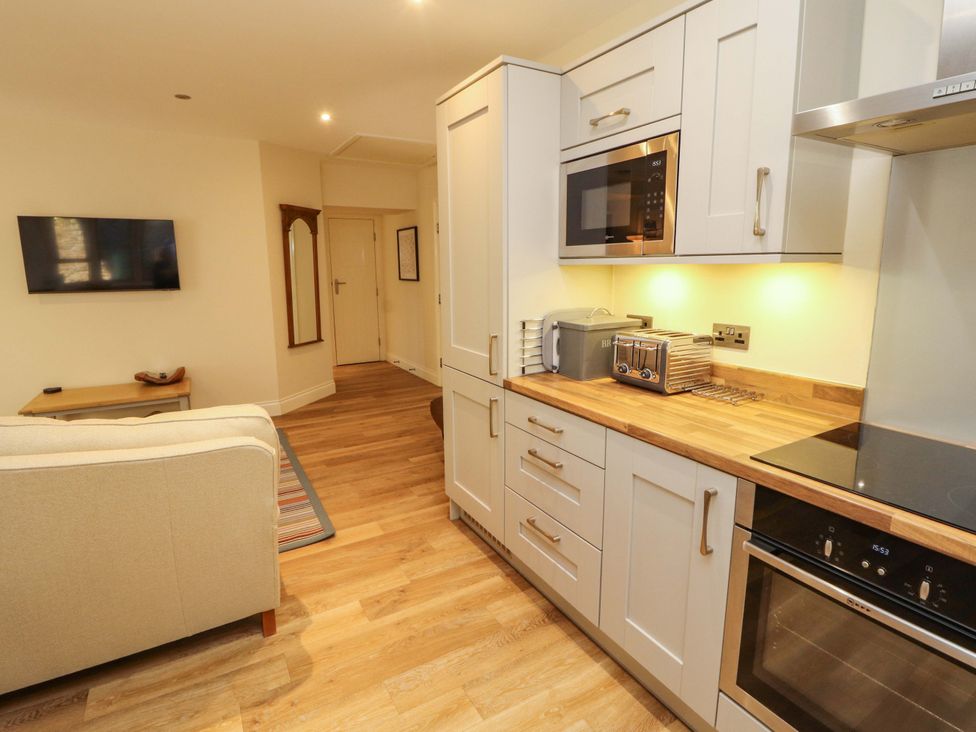 A kitchen with appliances and a sofa at Deer Wood At Applethwaite Hall in Windermere