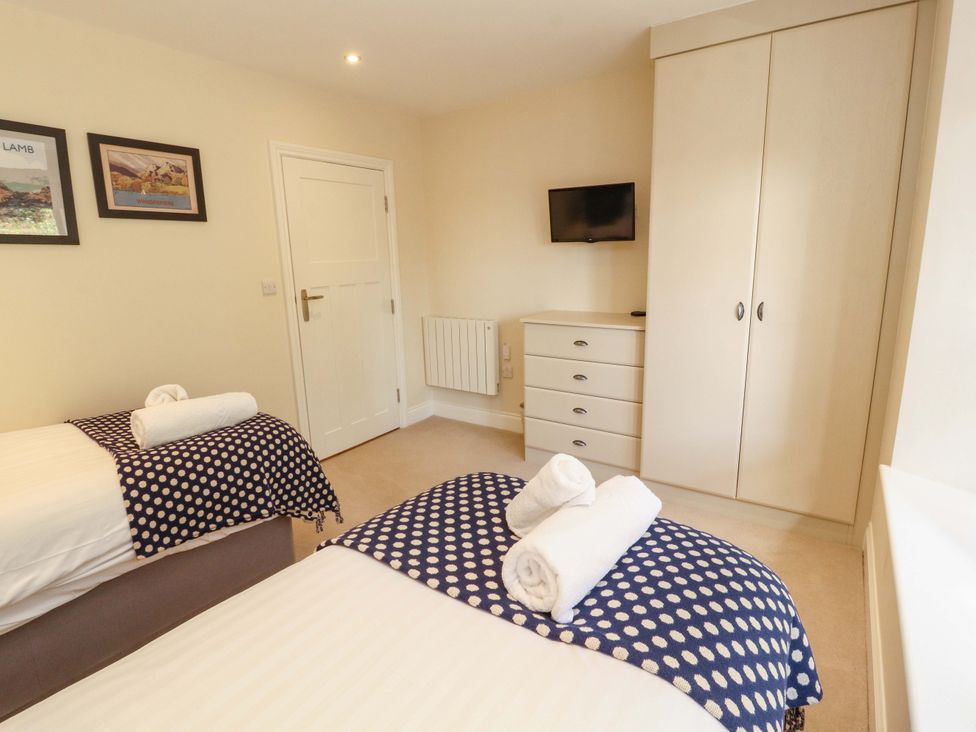 A bedroom with two beds and a tv at Deer Wood At Applethwaite Hall in Windermere