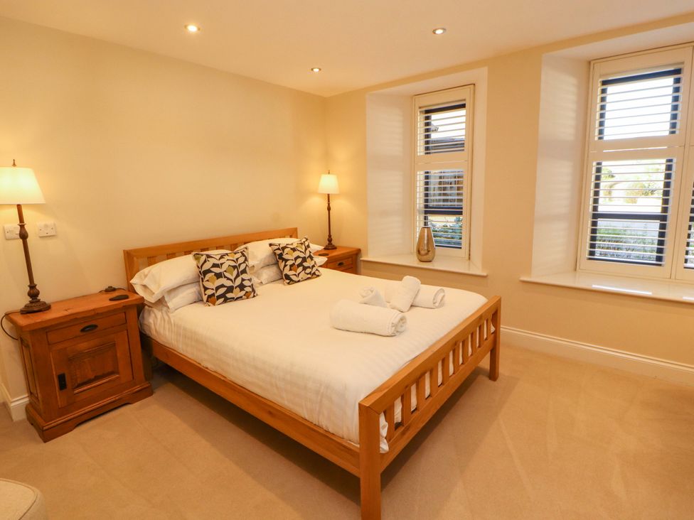 A bedroom with a bed and bedside table at Deer Wood At Applethwaite Hall in Windermere