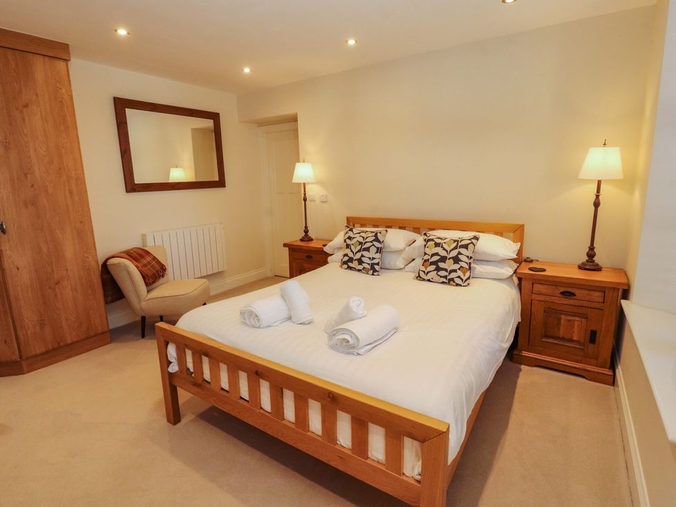 A bedroom with a bed and bedside tables at Deer Wood At Applethwaite Hall in Windermere