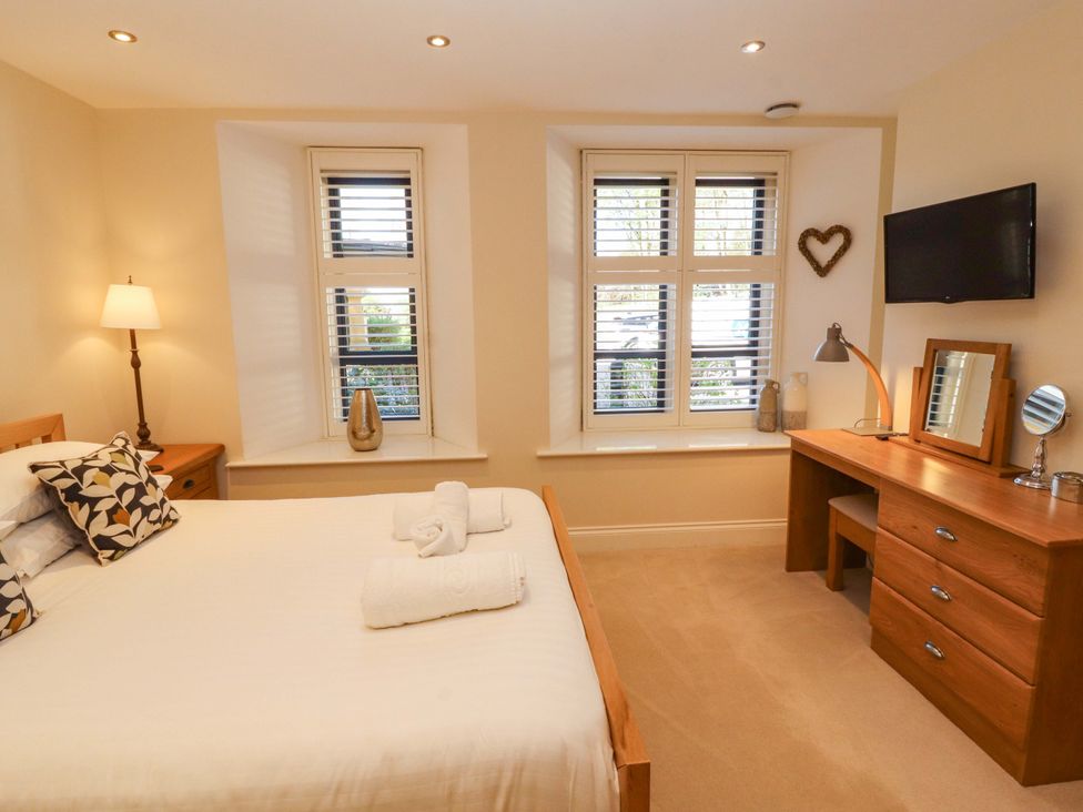 A bedroom with a bed and wooden dresser at Deer Wood At Applethwaite Hall Windermere