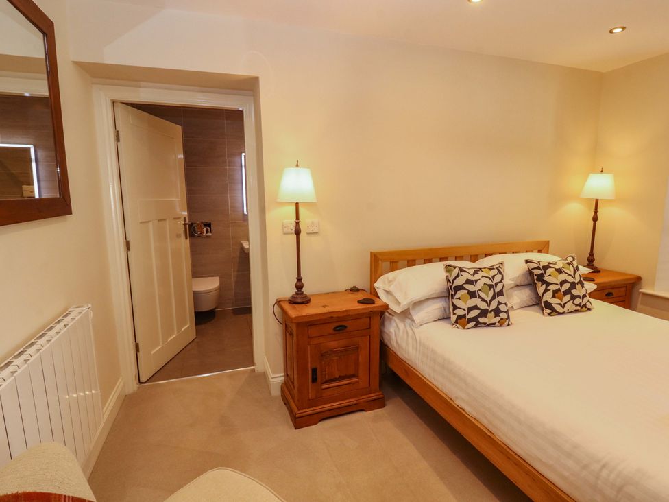 A bedroom with a bed and nightstands at Deer Wood At Applethwaite Hall in Windermere