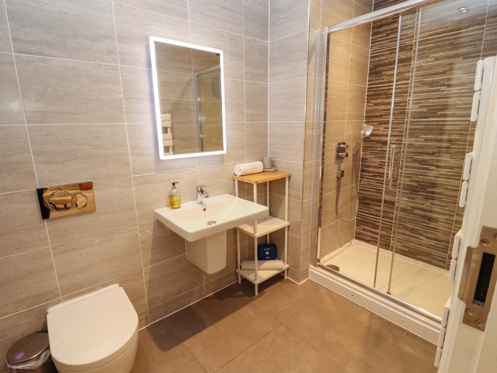 A bathroom with a shower, sink, and toilet at Deer Wood At Applethwaite Hall Windermere