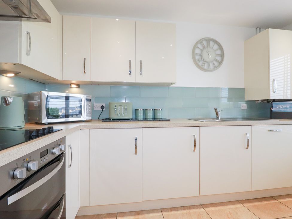A kitchen with appliances and cabinets at Blissful Ocean Breeze in Perranporth