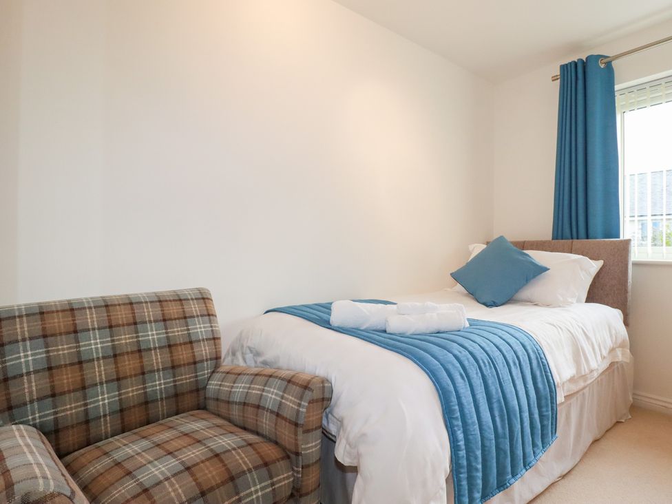 A bedroom with a single bed and a chair at Blissful Ocean Breeze in Perranporth