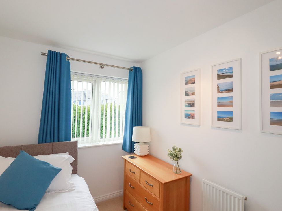 A bedroom with a bed, dresser, and window at Blissful Ocean Breeze Perranporth