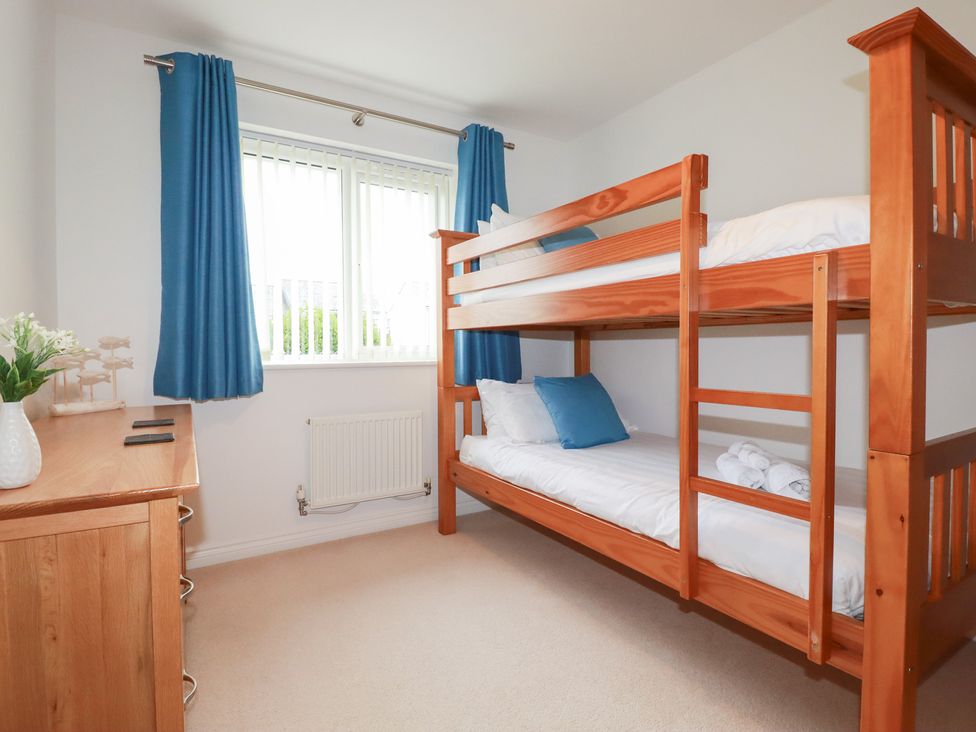 A bedroom with a bunk bed and dresser at Blissful Ocean Breeze in Perranporth