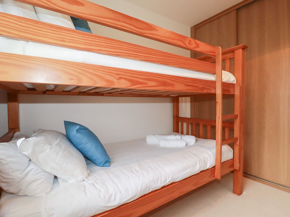 A bunk bed with white bedding and pillows at Blissful Ocean Breeze in Perranporth