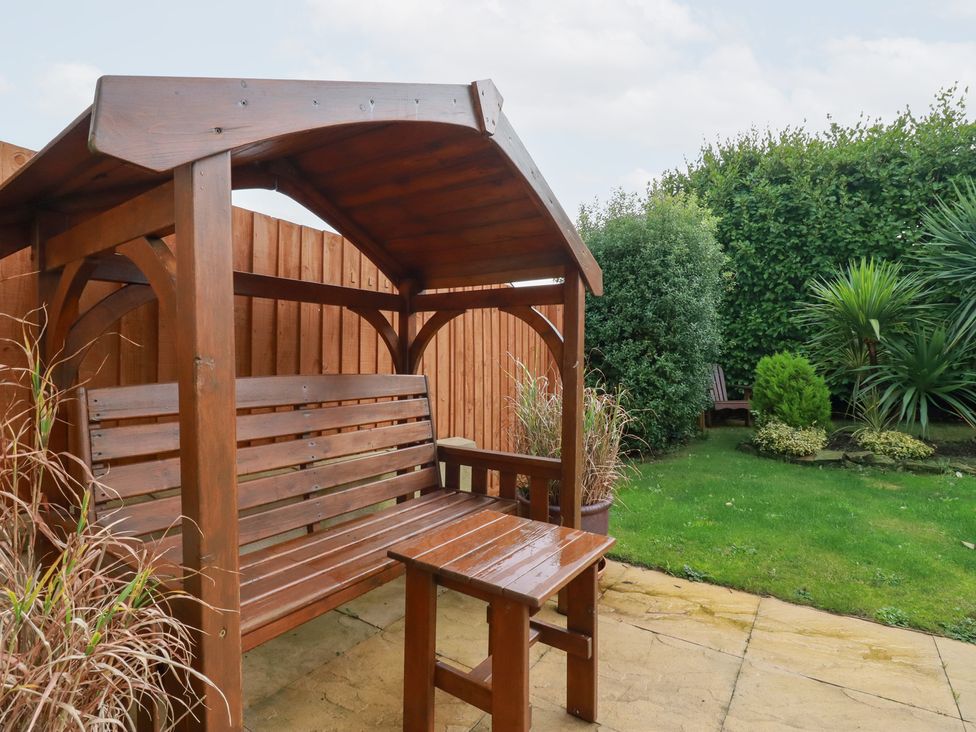 A bench and table in a garden at Blissful Ocean Breeze in Perranporth