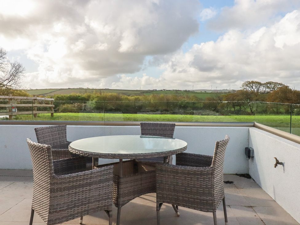 An outdoor seating area with a table and chairs at Lake View in Kestle Mill near Quintrell Downs