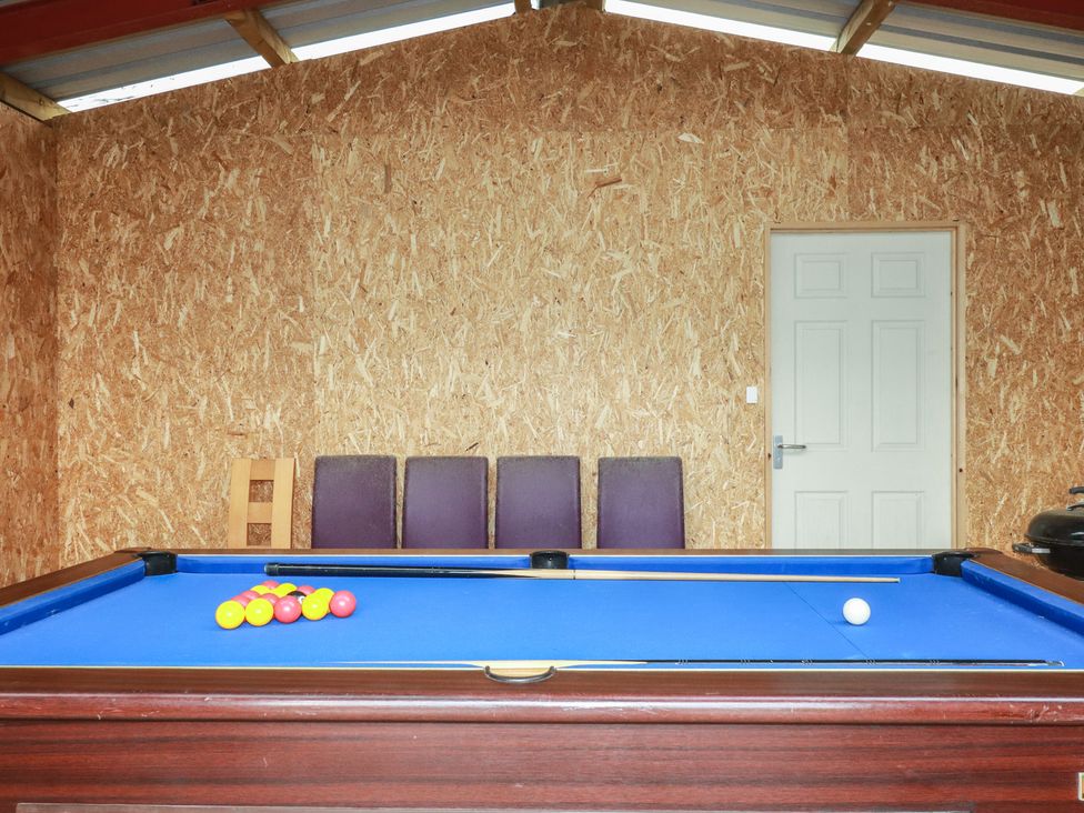 A game room with a pool table and chairs at Lake View in Kestle Mill near Quintrell Downs