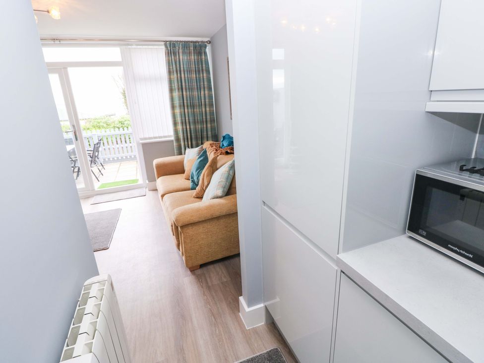 A living room with a sofa and a microwave at 3 Devon Court in Pembroke