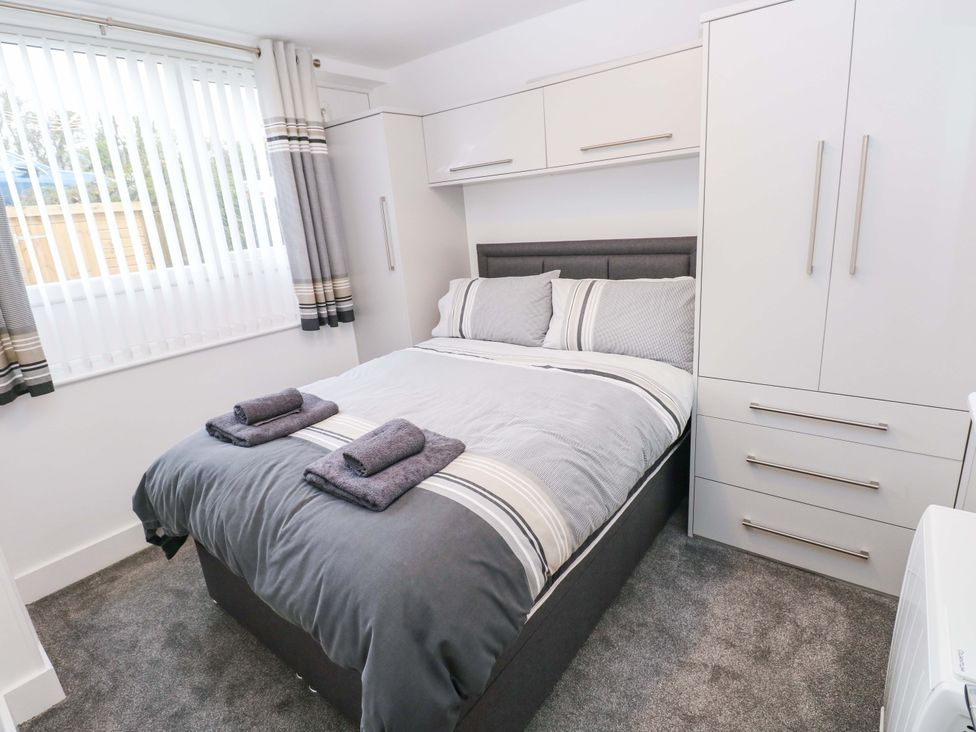 A bedroom with a bed and wardrobe at 3 Devon Court Pembroke