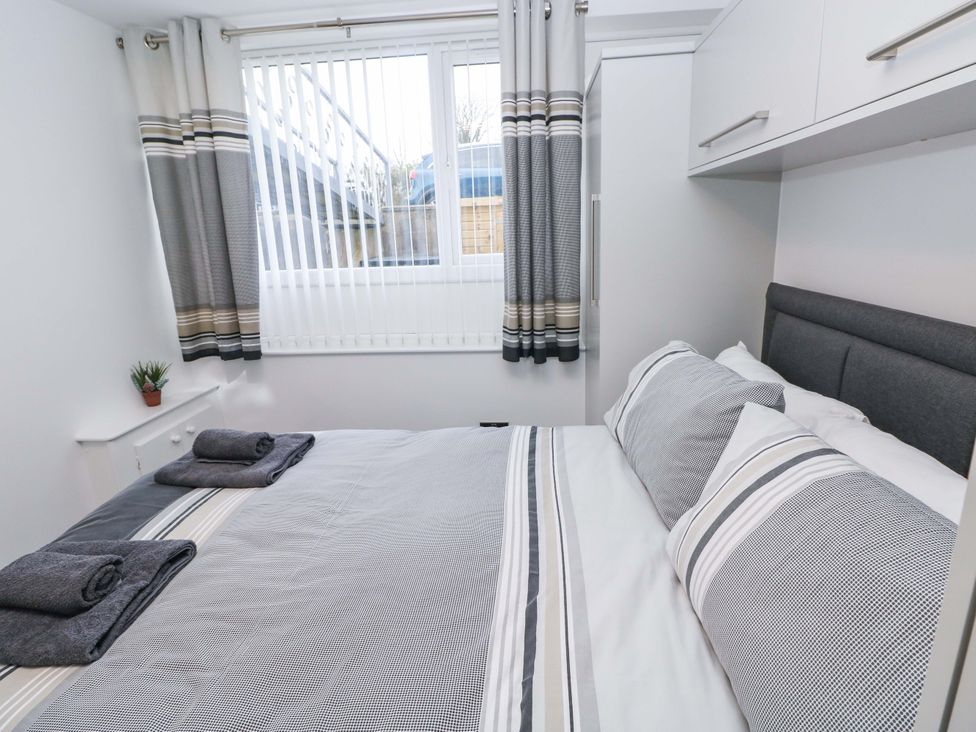 A bedroom with a bed and window at 3 Devon Court in Pembroke
