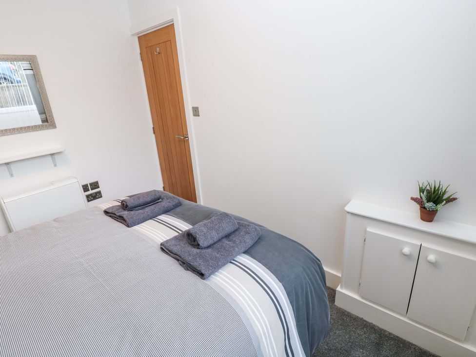 A bedroom with a bed and towels at 3 Devon Court in Pembroke