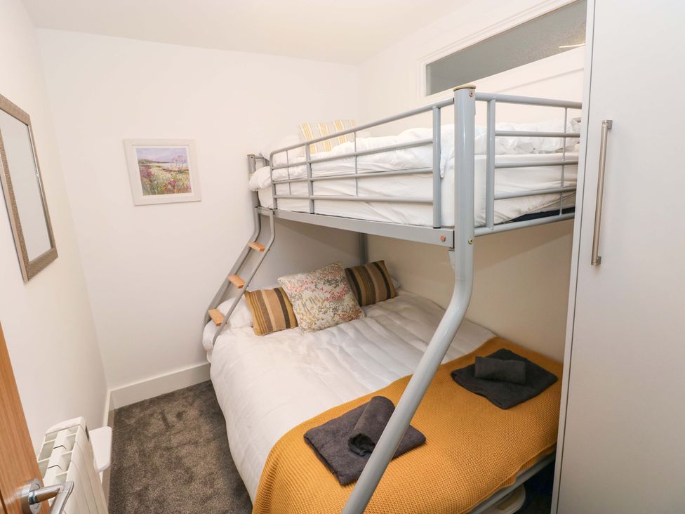 A bedroom with a bunk bed and a double bed at 3 Devon Court in Pembroke