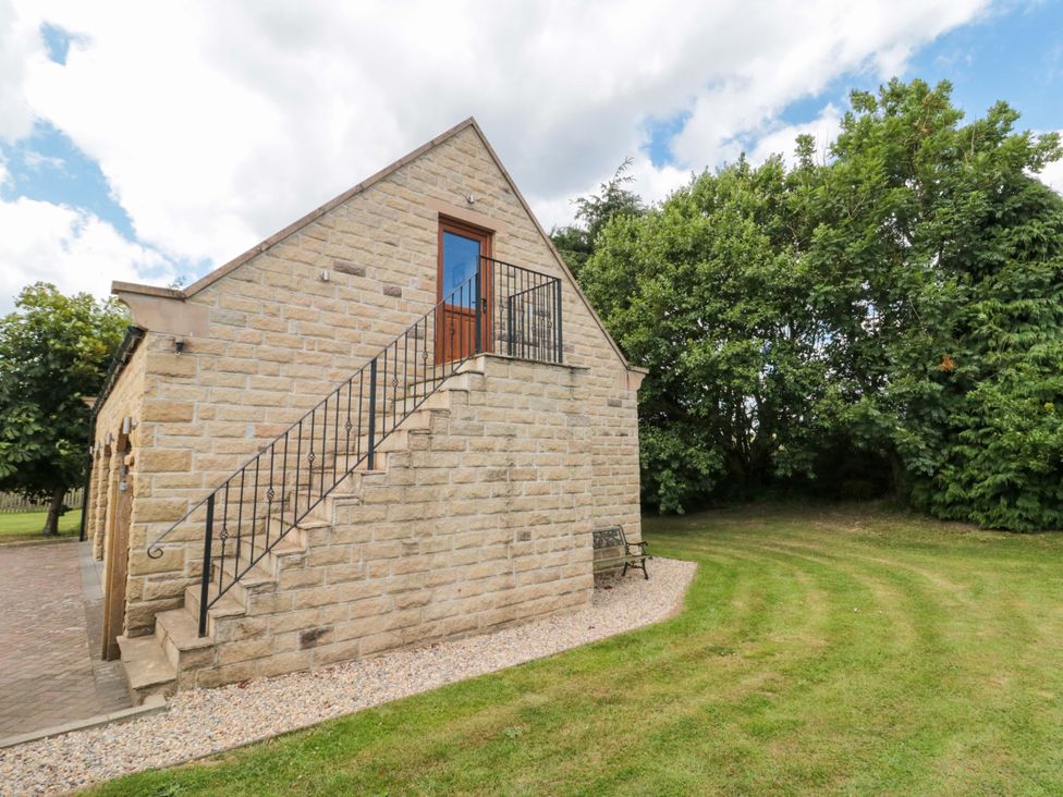 A stone house with stairs and a bench in the outdoor area at Heron Nest in Cloughton near Scarborough