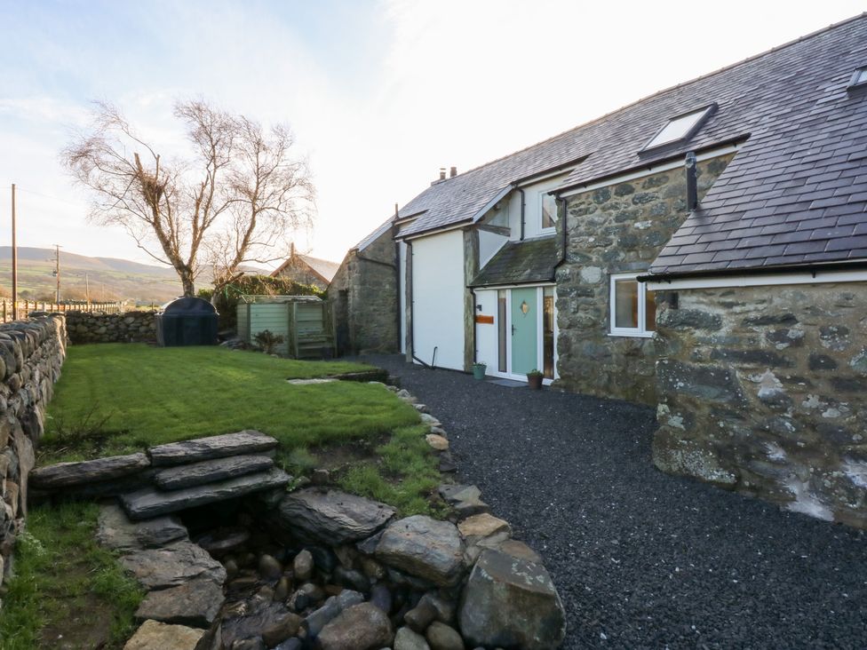 An outdoor view of a stone house with a garden at Yr Hen Felin in Dyffryn Ardudwy