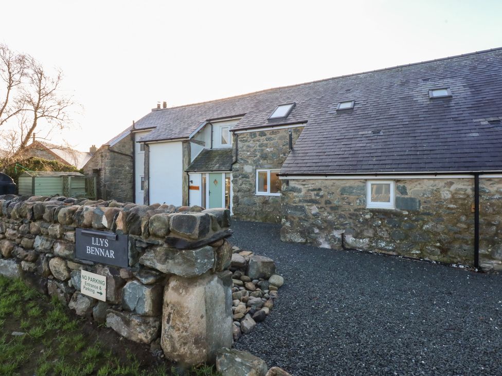 A stone house with a gravel driveway at Llys Bennar in Dyffryn Ardudwy