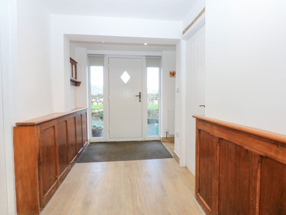 A hallway with a door and wooden panelling at Yr Hen Felin Dyffryn Ardudwy