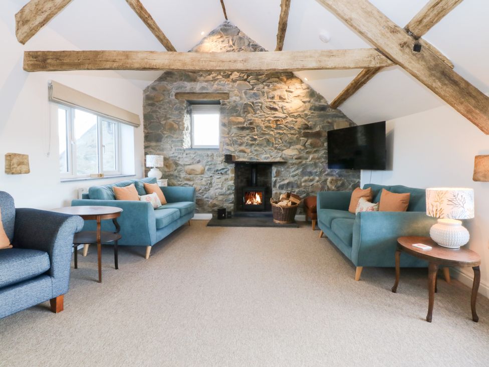 A living room with sofas and a fireplace at Yr Hen Felin in Dyffryn Ardudwy