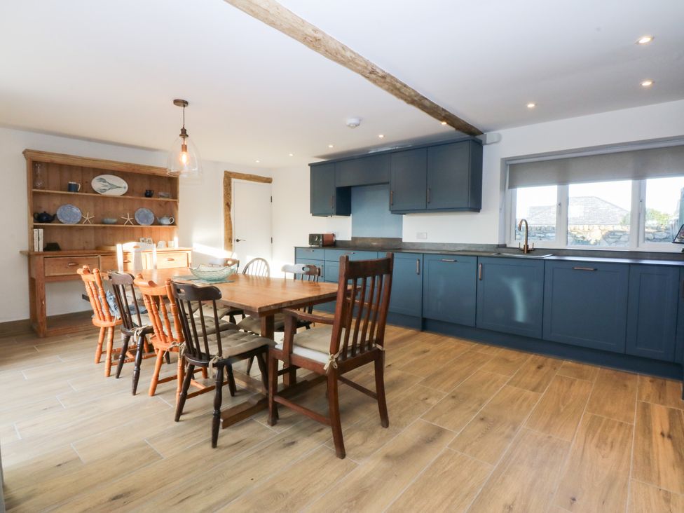 A kitchen with a dining table and chairs at Yr Hen Felin in Dyffryn Ardudwy