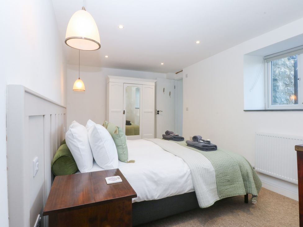 A bedroom with a bed and wardrobe at Yr Hen Felin Dyffryn Ardudwy