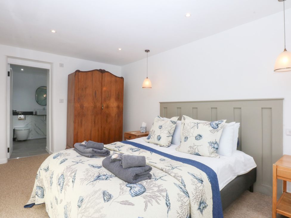 A bedroom with a bed and wardrobe at Yr Hen Felin Dyffryn Ardudwy