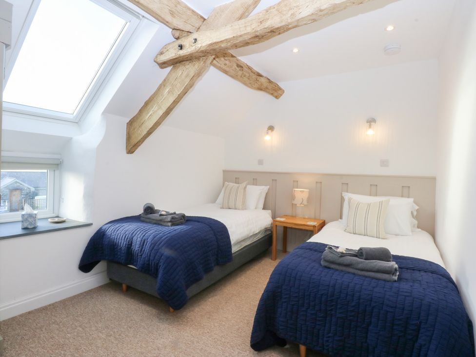 A bedroom with two beds and a window at Yr Hen Felin in Dyffryn Ardudwy