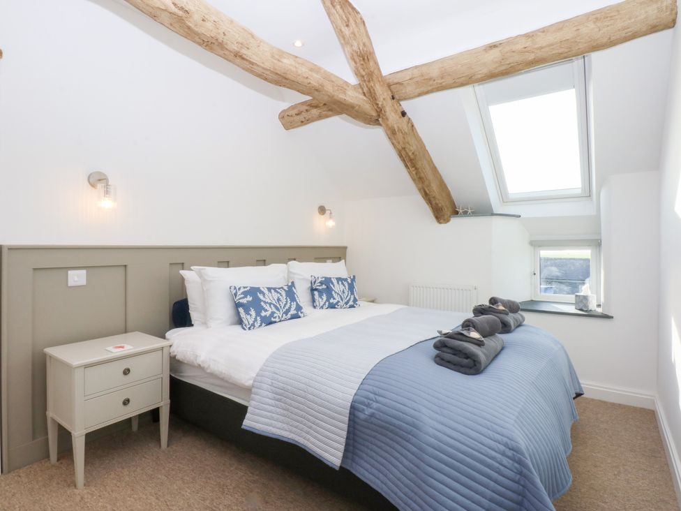 A bedroom with a bed and bedside table at Yr Hen Felin in Dyffryn Ardudwy