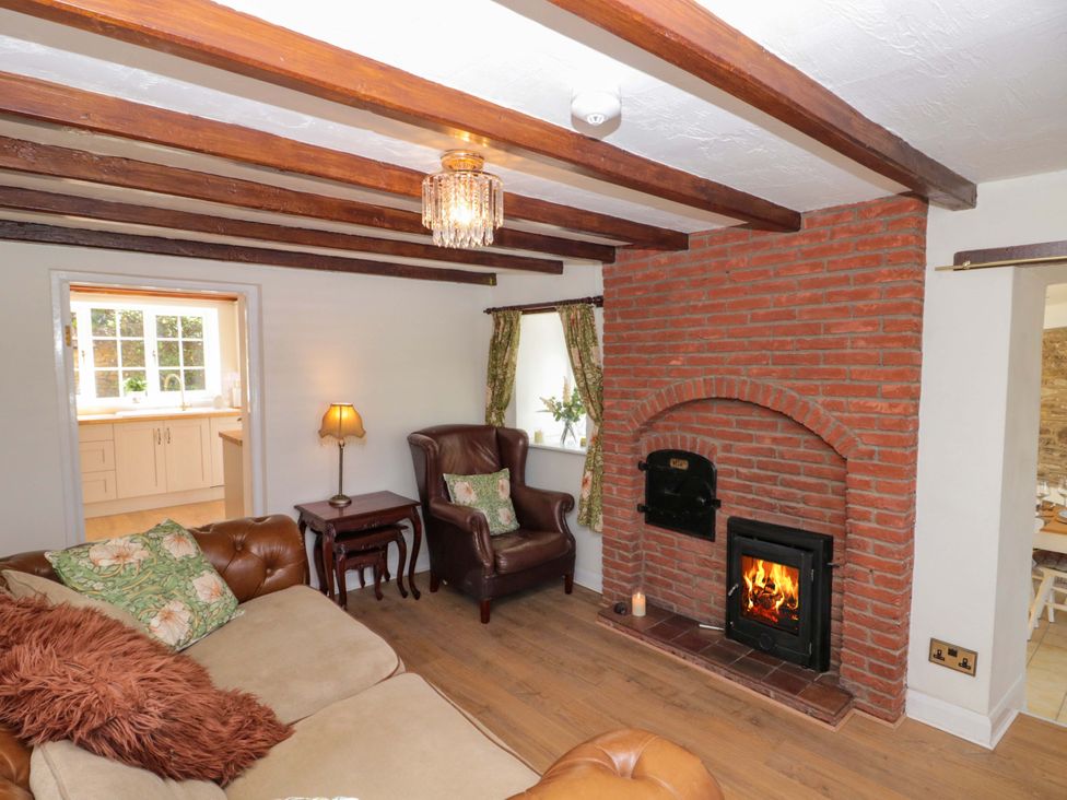 A living room with a fireplace and sofa at Rose Cottage East Ayton